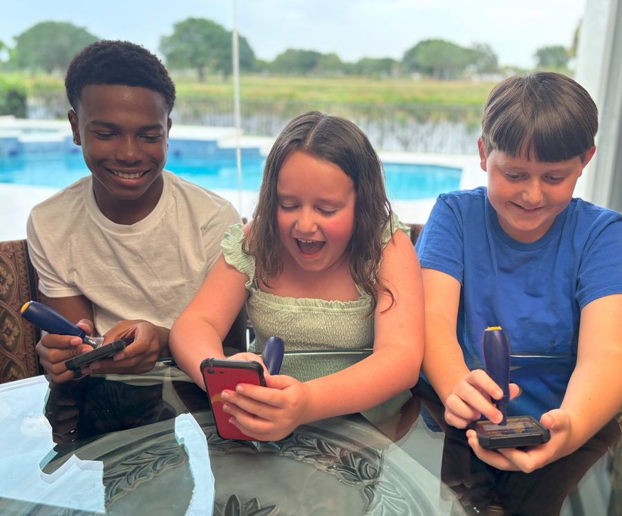 Group of kids playing mobile games together using Sideklick devices